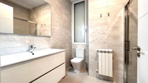 een badkamer met een wastafel, een toilet en een spiegel bij Larramendi City Center in San Sebastian