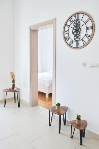 a room with a clock on the wall and two tables at Lavander Bay C03 in Kotor