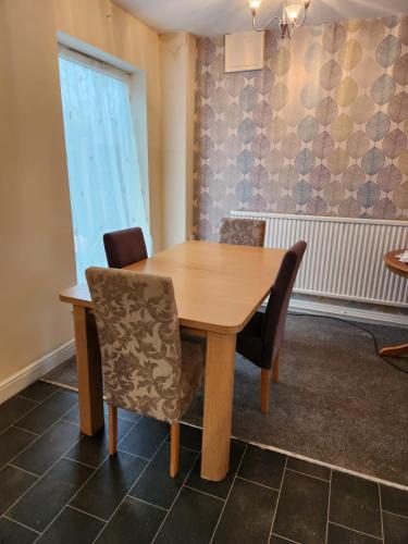 a wooden table and chairs in a room at Fox Hollies Shared House in Birmingham