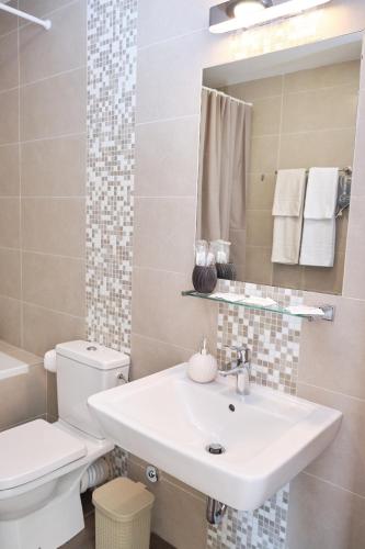 a white bathroom with a sink and a toilet at Lavander Bay C03 in Kotor