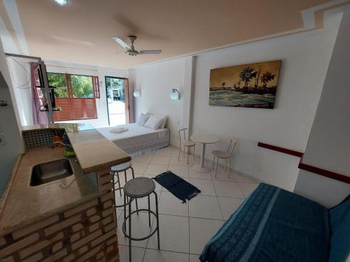 a living room with a kitchen and a room with a couch at Arraial Flats in Arraial do Cabo