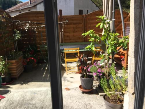une terrasse avec des plantes en pot et une clôture dans l'établissement plein pied village, à Montrond