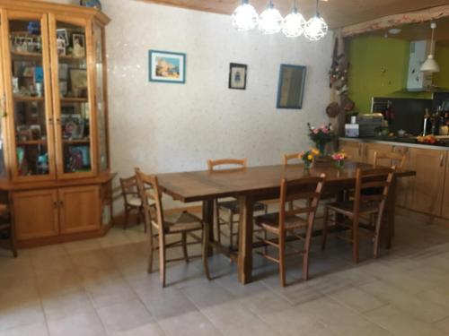 une salle à manger avec une table et des chaises en bois dans l'établissement plein pied village, à Montrond