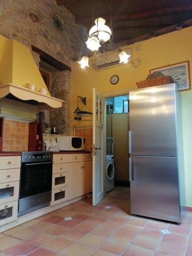 a kitchen with a stainless steel refrigerator in it at Large Stone Villa with garden. in Khánia