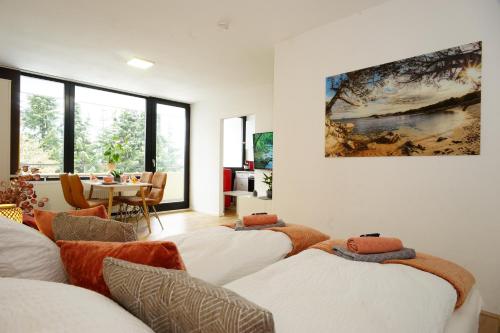 a living room with four white couches and a painting on the wall at RELAX - ORANGE mit Pool und Sauna in Sonthofen