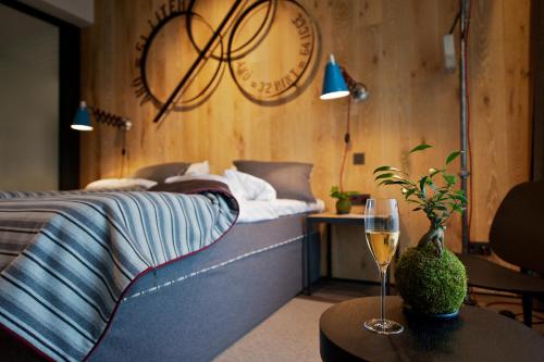 Schlafzimmer mit einem Bett und einem Tisch mit einem Glas Wein in der Unterkunft Kreinbacher Birtok in Somlóvásárhely