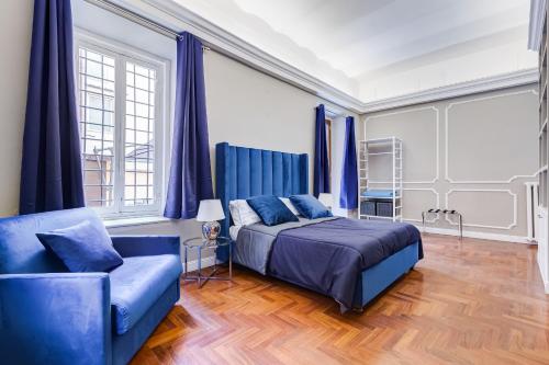 - une chambre avec un lit bleu et un canapé dans l'établissement SPANISH GARDEN, à Rome