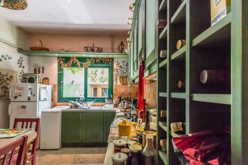 kuchnia z zielonymi szafkami i białą lodówką w obiekcie Nano's House w mieście Kala Nera