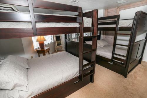 two bunk beds in a room with a desk and a lamp at Seven Springs Stoneridge 3 Bedroom Standard Condo, Mountain Views! condo in Champion