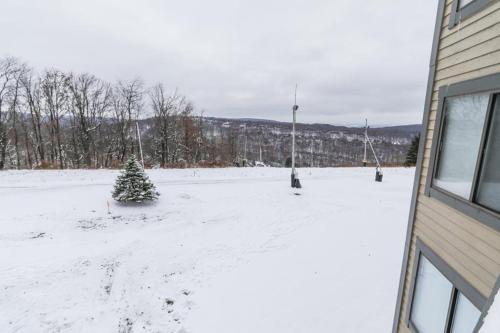 a snow covered yard with a christmas tree and a building at Seven Springs Stoneridge 3 Bedroom Standard Condo, Mountain Views! condo in Champion
