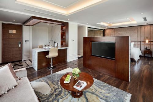 a living room with a couch and a television at Ravatel Luxury Hotel Bac Giang in Bắc Giang