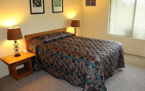 a bedroom with a bed and a table with two lamps at Seven Springs Stoneridge 1 Bedroom Loft Standard Condo, Pet Friendly! condo in Champion