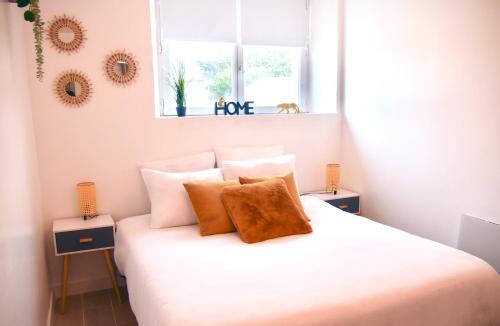 une chambre avec un lit avec des draps blancs et des oreillers dans l'établissement Oasis Sun, à Sens