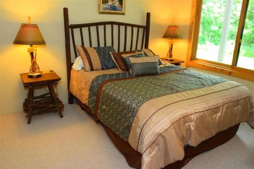 ein Schlafzimmer mit einem Bett und zwei Lampen an Tischen in der Unterkunft Seven Springs Sunridge 2 Bedroom Standard Condo, Ski-In Out! condo in Champion