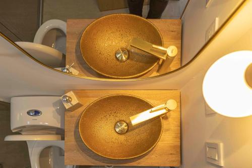 a bathroom with a gold sink and a mirror at FINCA MONARCA in Guatapé