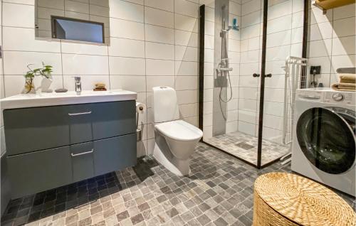 een badkamer met een toilet, een wastafel en een wasmachine bij Cozy Home In Vallda With Kitchen in Vallda