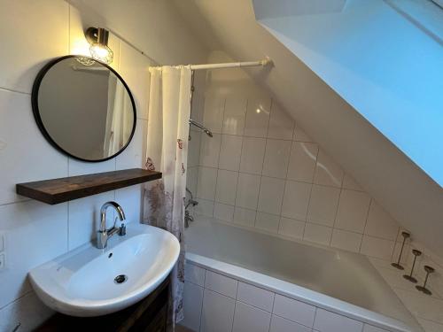 a bathroom with a sink and a tub and a mirror at Charmantes Appartement - München in Munich