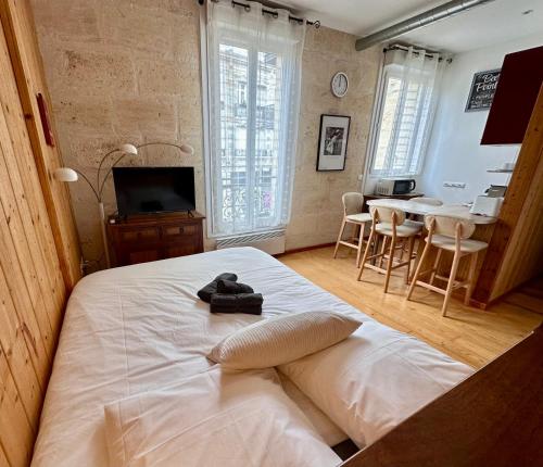 een slaapkamer met een wit bed en een tafel en stoelen bij Le Woody, Centre-ville, Parking gratuit in Bordeaux