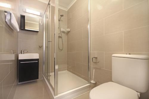 a bathroom with a shower and a toilet and a sink at St Mark Hotel in London