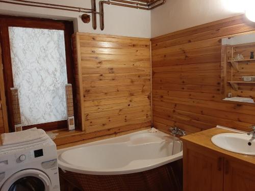 a bathroom with a tub and a washing machine at Szent Kristóf Udvarház -Pogácsás Porta 