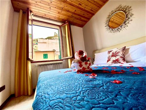 un osito de peluche sentado en una cama en un dormitorio en Cà Vivaldi penthouse 5terreparco, en Riomaggiore
