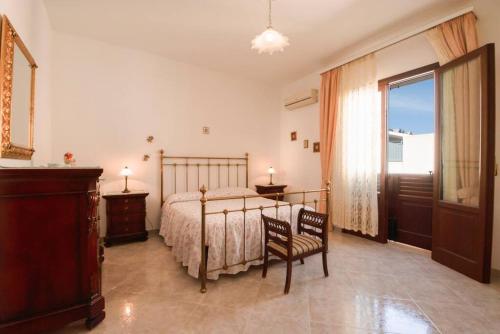 une chambre avec un lit, une chaise et une fenêtre dans l'établissement A pochi passi dal mare, à San Vito Lo Capo