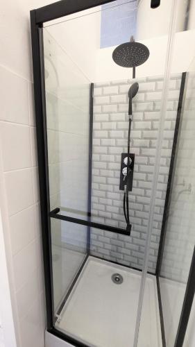 d'une douche avec une porte en verre et un téléphone. dans l'établissement Appartement Cosy - En face de la gare, au centre ville, à Épinal