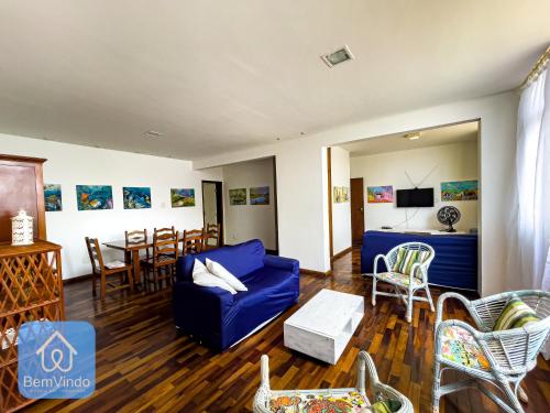 a living room with a blue couch and a table at Apartamento completo em frente ao Farol da Barra in Salvador