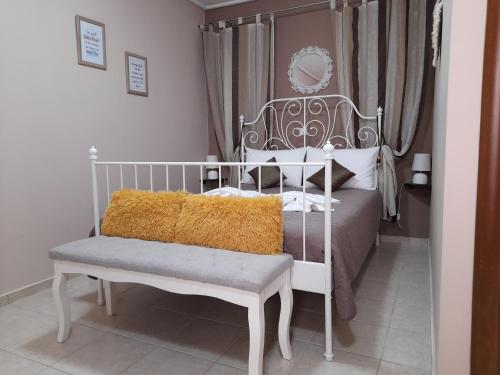 a bedroom with a white bed and a bench and curtains at Nikos Studio in Kalyves