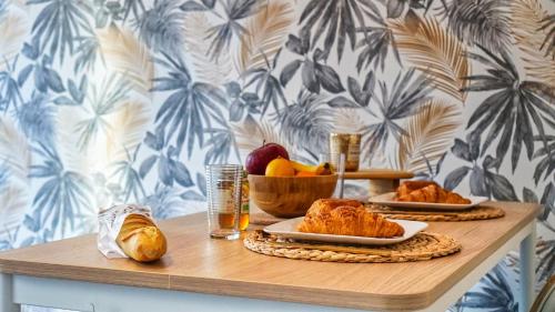 - une table avec deux assiettes de nourriture et un bol de fruits dans l'établissement Appartement Cosy - En face de la gare, au centre ville, à Épinal