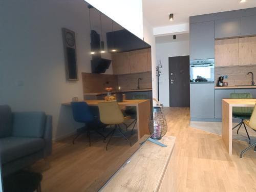 a kitchen and living room with a table and chairs at Tesla Point in Osijek