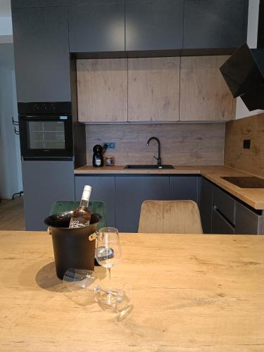 a wooden table with two glasses and a bottle of wine at Tesla Point in Osijek