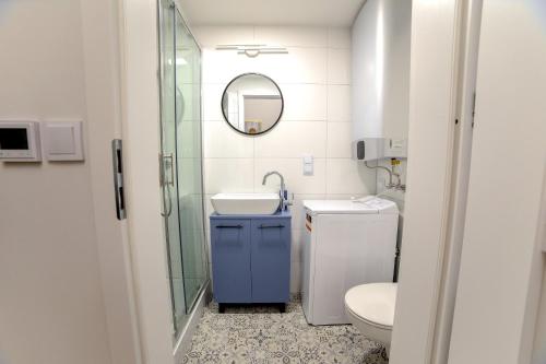 y baño con aseo, lavabo y espejo. en CracWoW Saint Sebastian Apartments, en Cracovia