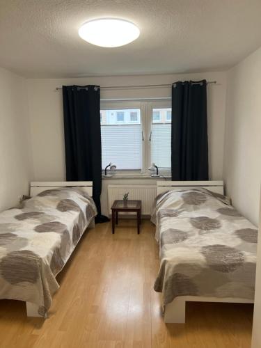 um quarto com 2 camas e uma janela com cortinas em Messe Zimmer/Ferienwohnung Hannover em Hanôver