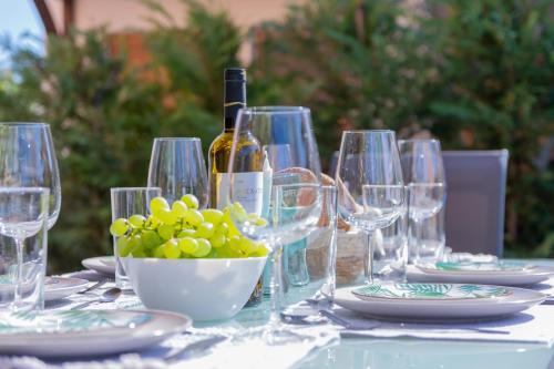 a table with wine glasses and a bowl of grapes at khouse - Personal Paradise in Neos Marmaras