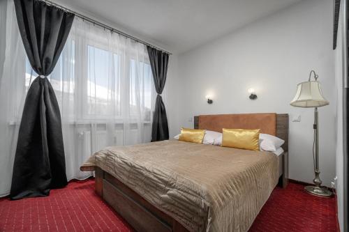 een slaapkamer met een bed en een groot raam bij Apartman pod Gerlachom s wellness in Vysoke Tatry - Horny Smokovec