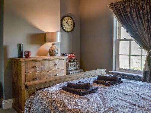 a bedroom with a bed with a clock on the wall at Loyal Cerise Bondgate in Selby