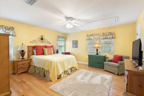 ein Schlafzimmer mit einem Bett, einem Sofa und einem TV in der Unterkunft Village Walk - 104 Mews Circle in King City
