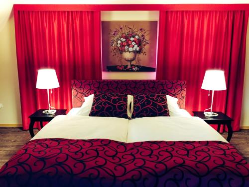 Schlafzimmer mit einem großen Bett und roten Vorhängen in der Unterkunft Maison de la Sauer - Bed and Breakfast | Chambre d’hôtes | Ferienhaus in Munchhausen