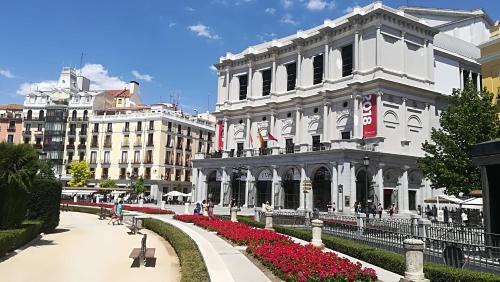 a white building with red flowers in front of it at Villa "Luna de Segovia" in Leganés