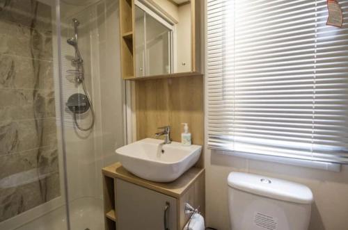een badkamer met een wastafel, een toilet en een douche bij Hayley's Holiday Haven in Weeley