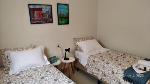 sypialnia z 2 łóżkami i lampką na stole w obiekcie Apartamento Uberlândia - Centro com garagem w mieście Uberlândia