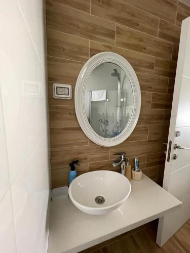 a bathroom with a white sink and a mirror at Lev Eilat Suites in Eilat