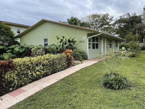 uma pequena casa verde com um jardim em Centrally located between downtown Fort Lauderdale, Airport and the Beach em Fort Lauderdale