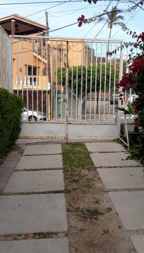 a walkway in front of a building with a fence at Departamentos con Alberca in Mazatlán