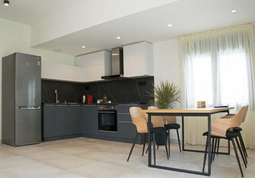 a kitchen with a table and chairs and a refrigerator at Angelbay Bungalows in Agia Triada