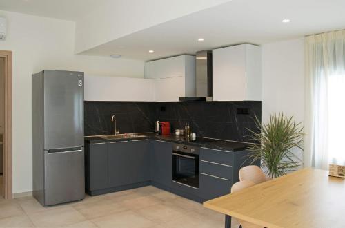 a kitchen with blue cabinets and a stainless steel refrigerator at Angelbay Bungalows in Agia Triada