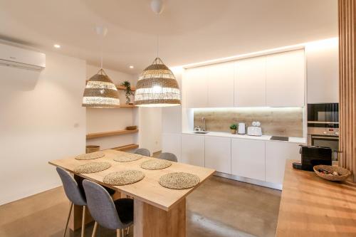 a kitchen with a wooden table and chairs at Atelier 321- Porto- Praia- Rio- Terraço in Vila Nova de Gaia