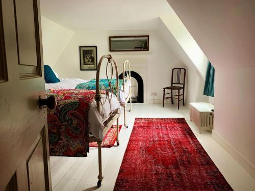 a bedroom with a bed and a red rug at The Old Wing in Alexandria