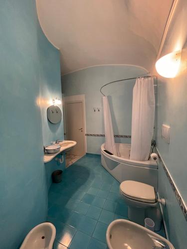 a bathroom with two toilets and a tub and a sink at Bed & Breakfast Scià Dina in Toirano